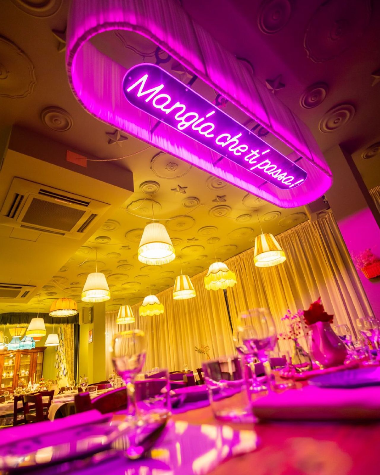 Sala di Citto con insegna al neon magenta