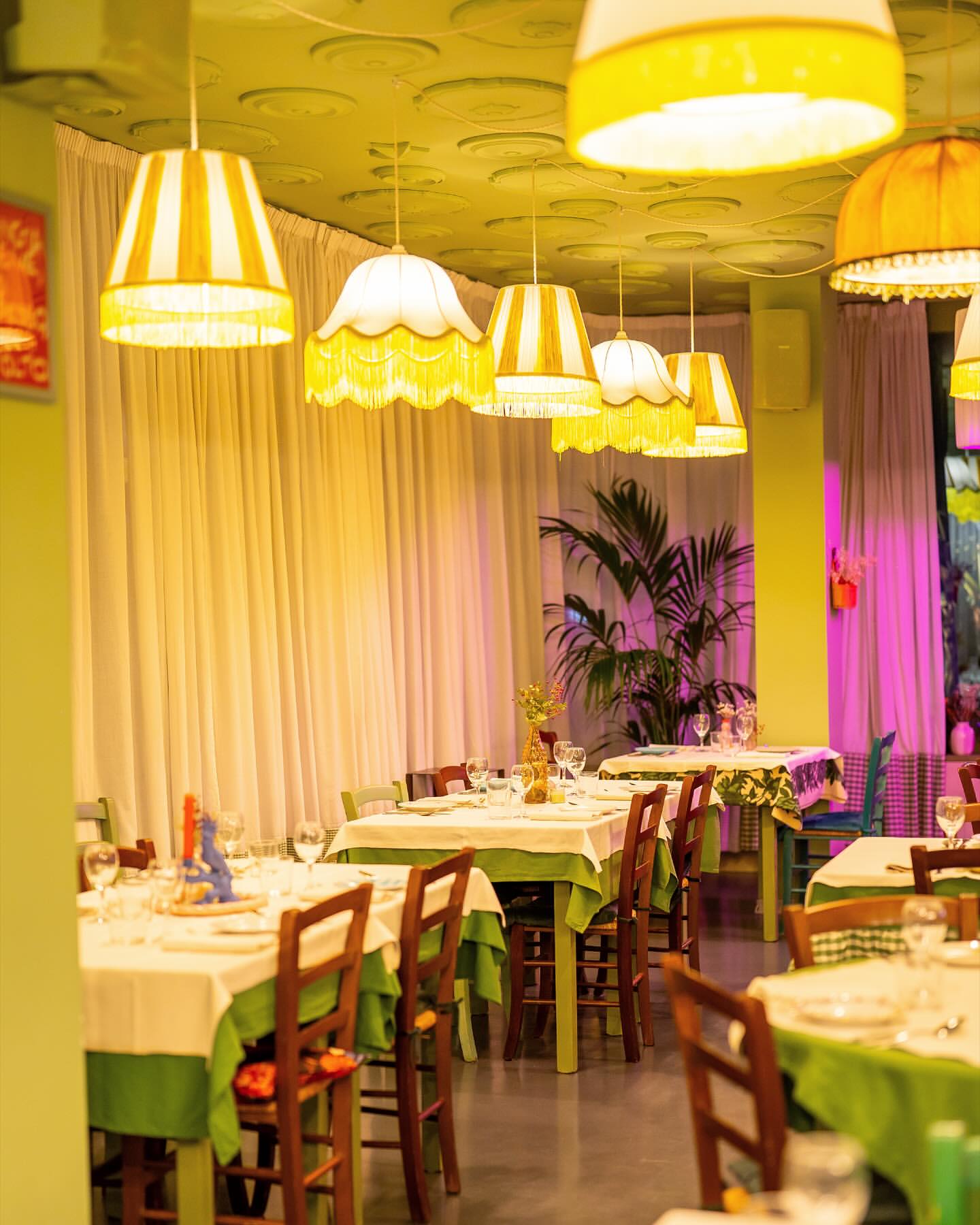 Sala con lampade calde e tavoli apparecchiati